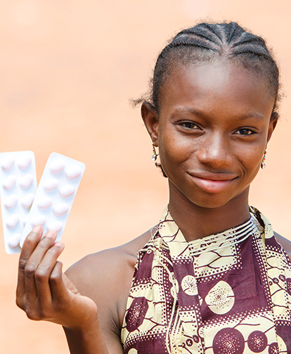 African young girl showing pills for medicine & healthcare projects in Africa.